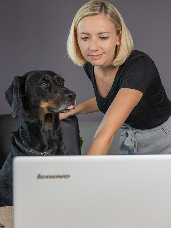 Nicole mit Hund Leo vor dem Laptop