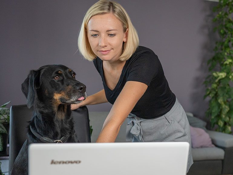 Nicole mit Hund Leo vor dem Laptop