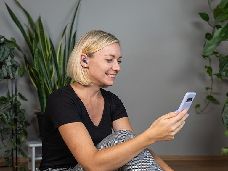 Nicole beim Social Media Mentoring mit Smartphone und Ear Pods