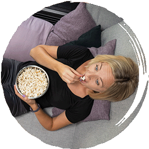 Nicole mit Popcorn essend auf der Couch